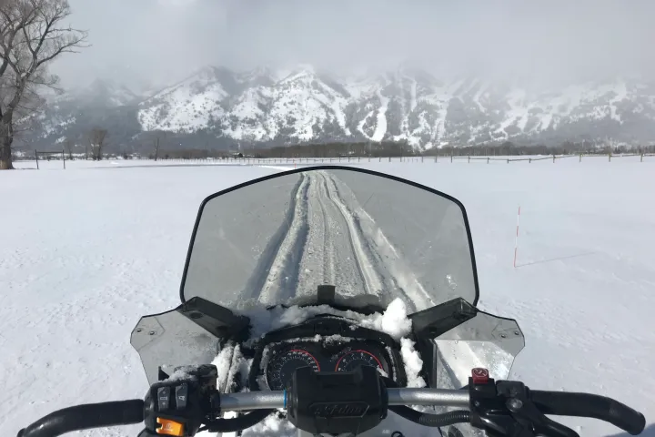 a person sitting on top of a snow covered slope