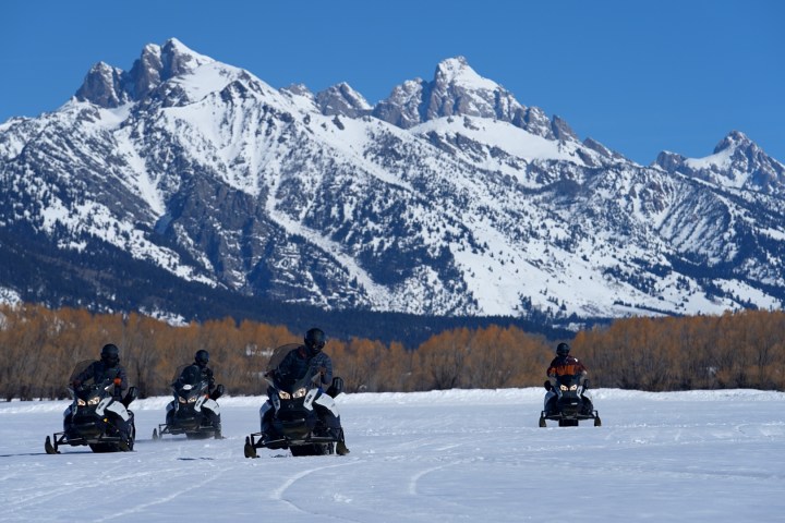 a group of people standing on top of a snow covered mountain