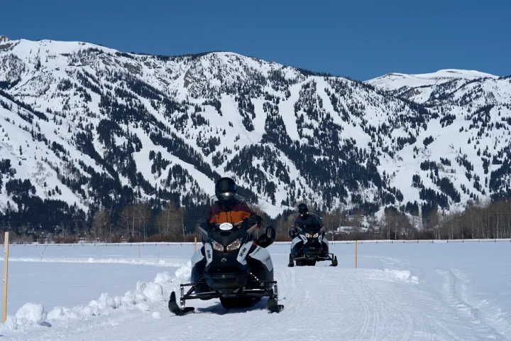 a man riding a snowboard down a snow covered mountain