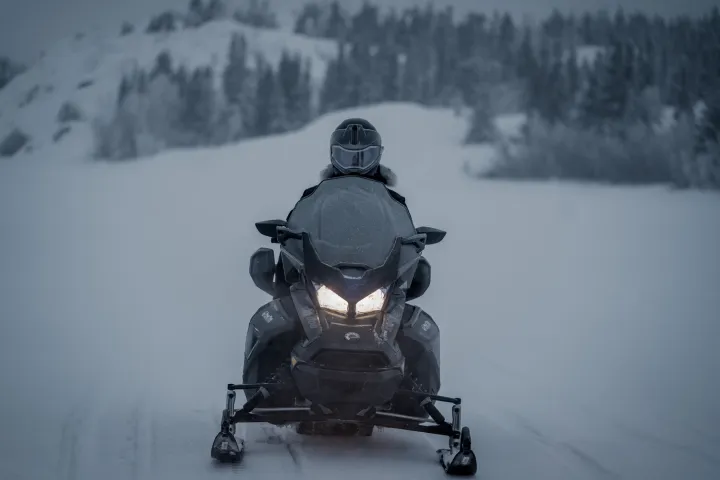 a man riding a snowboard down a snow covered slope