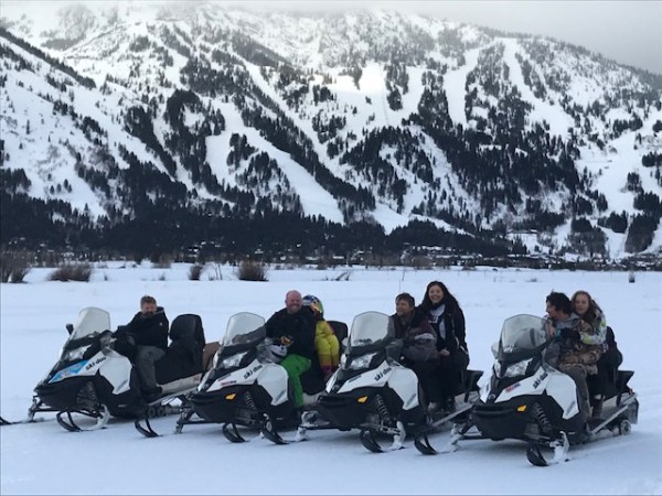 a group of people sitting on top of a snow covered mountain